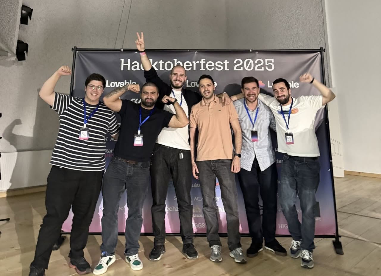 HACKTOBERFEST 2025 organizers celebrating on stage in front of the event banner